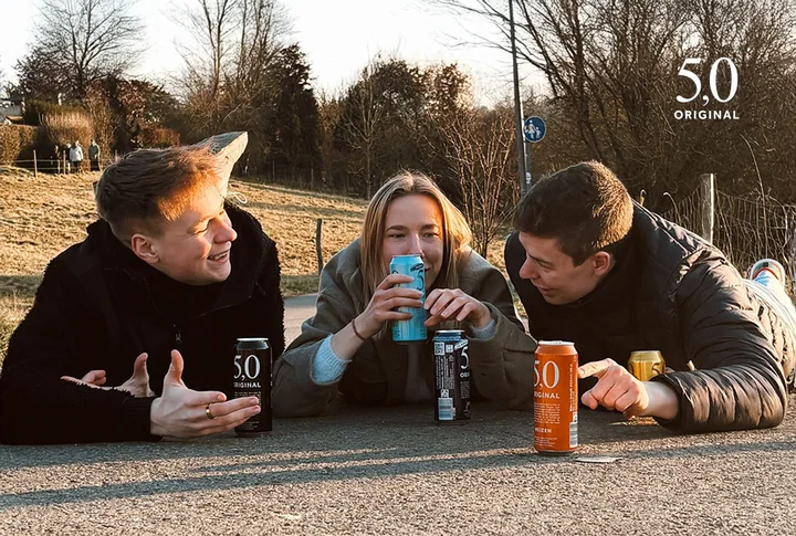 Mitglieder der 5,0 WG im Freien mit Getränkedosen.
