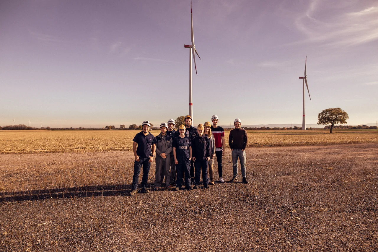 Teilnehmende stehen gemeinsam im Windpark Freckenfeld.