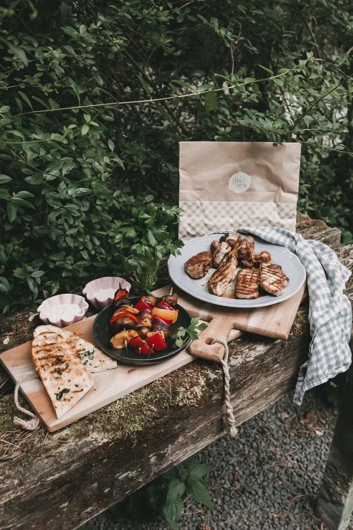 HelloBBQ-Gerichte auf einem Tisch im Grünen.