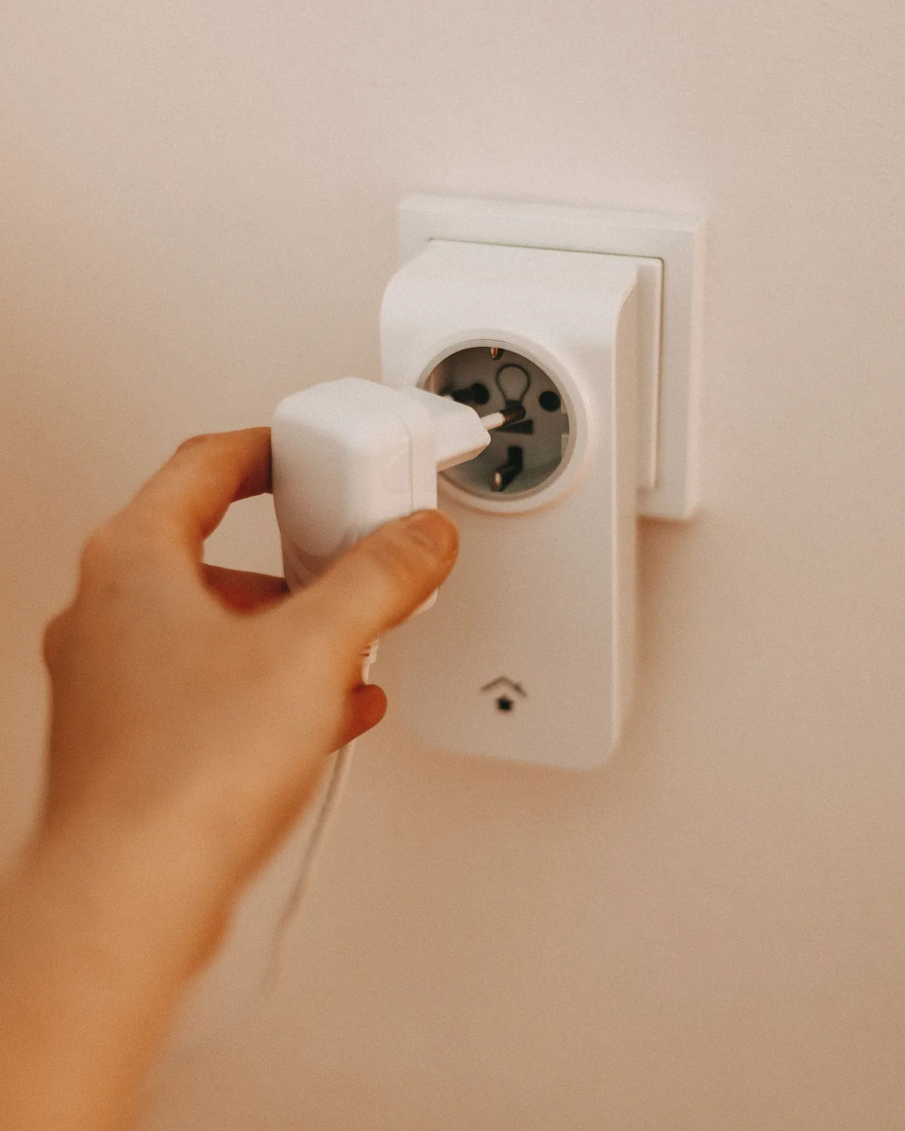 Hand steckt einen innogy SmartHome-Zwischenstecker in die Steckdose