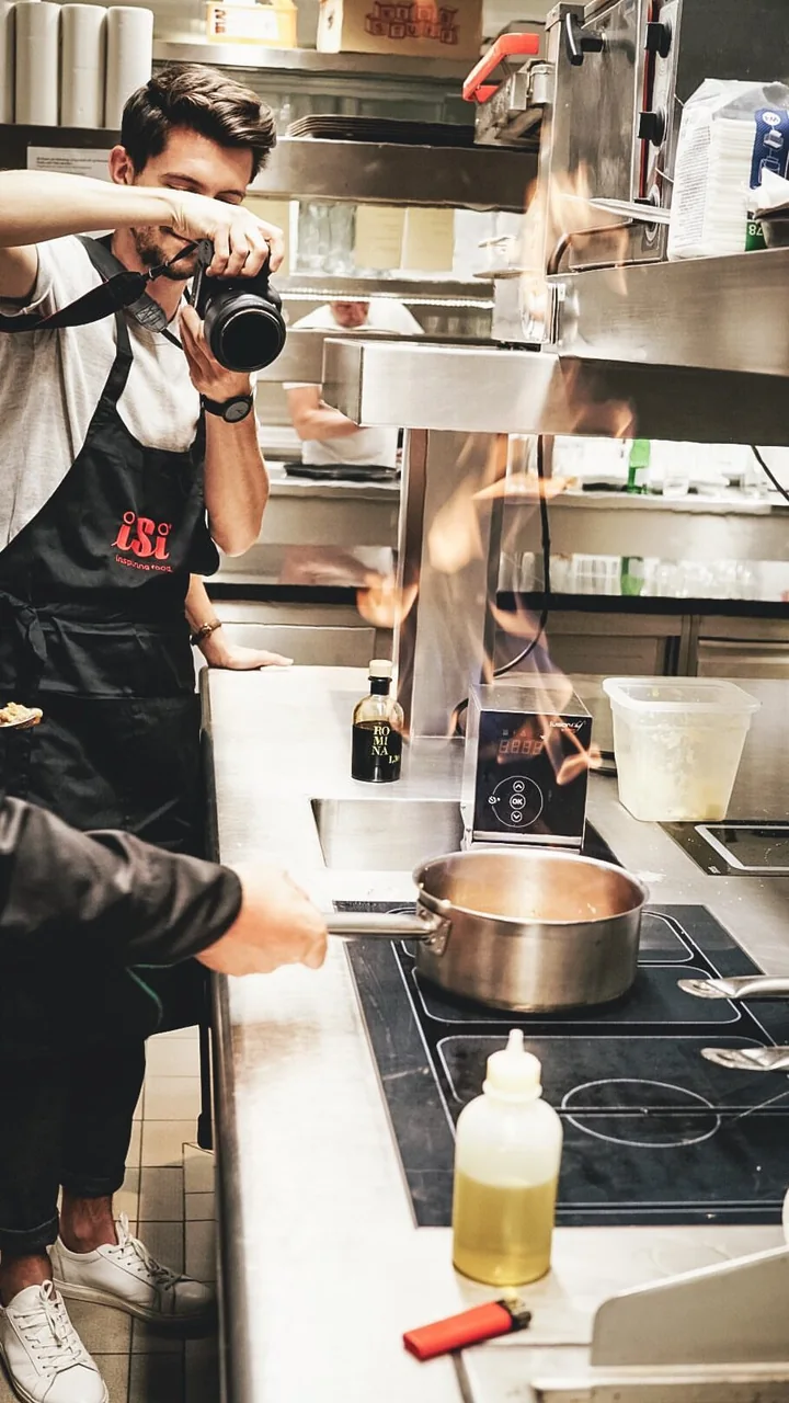Menschen kochen und richten gemeinsam in einer professionellen Küche an.