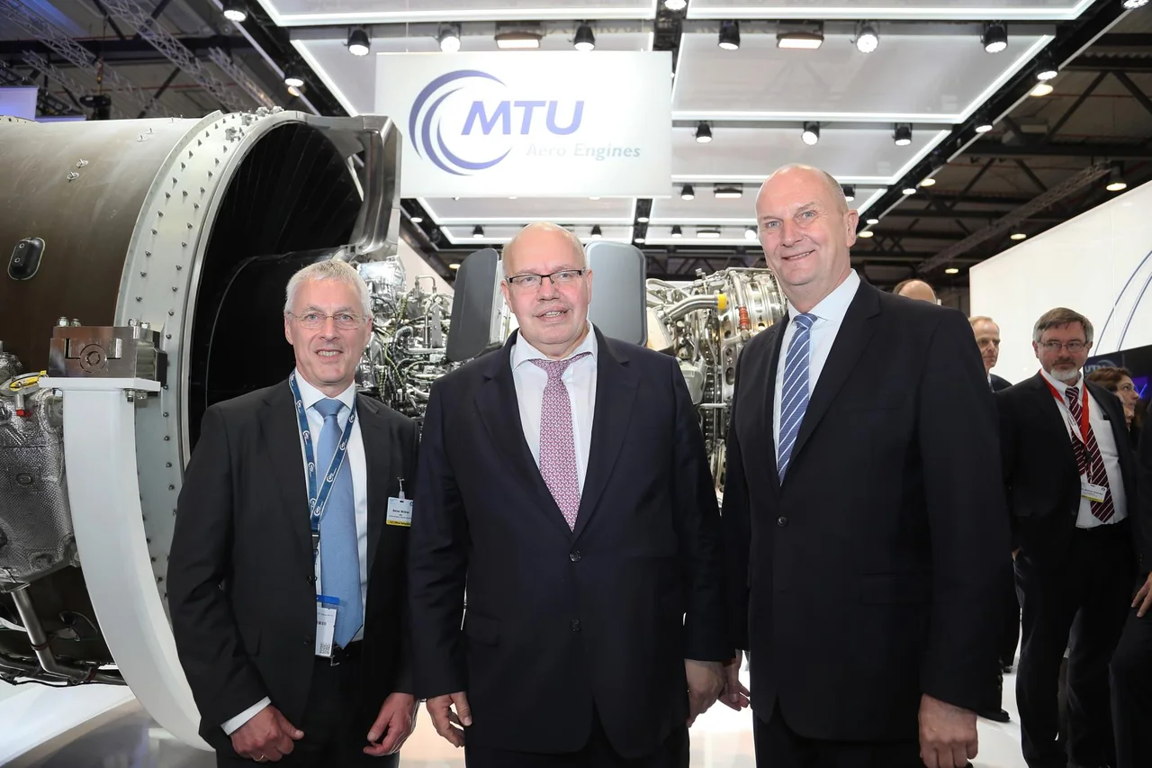 Besuchergruppe vor einem MTU-Triebwerksexponat.
