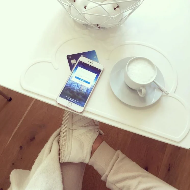 Smartphone auf einem Tisch neben einer Tasse als Motiv der o2-Banking-Aktion.
