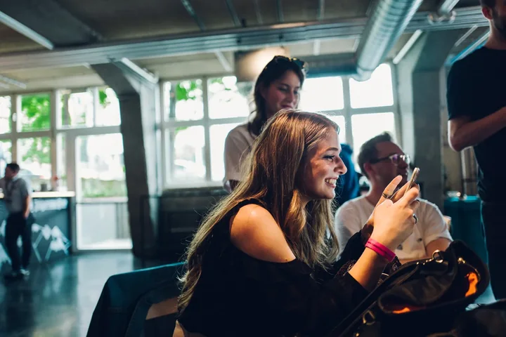 Creatorin mit Smartphone in einer hellen Location.