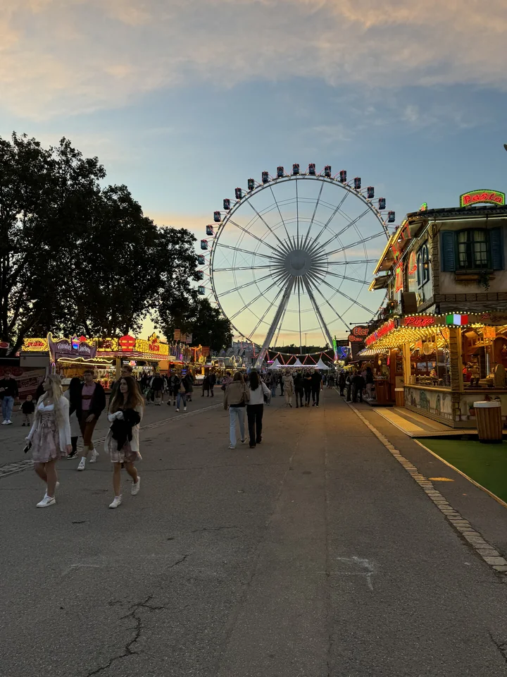 Menschen erleben den Wasen in Stuttgart am Abend.