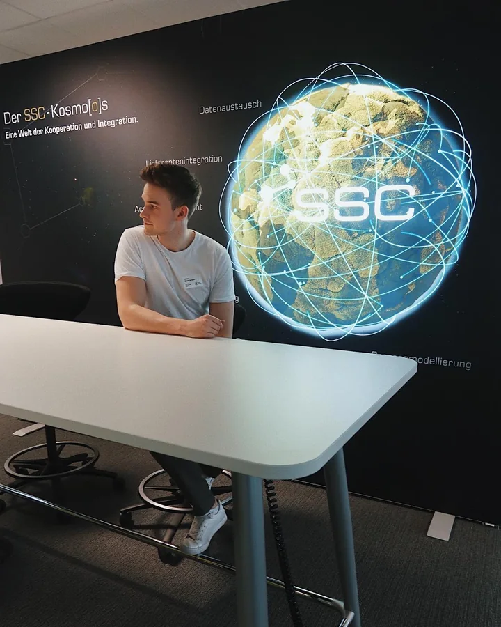 Creator bei SSC Services vor einer digitalen Globusdarstellung